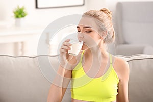 Young woman drinking milk at home. Diet food concept