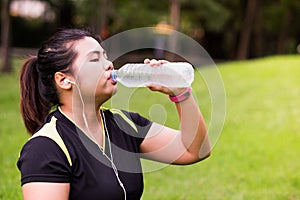 Young woman drinking naturel water from bottle after exercise