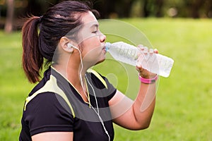 Young woman drinking naturel water from bottle after exercise