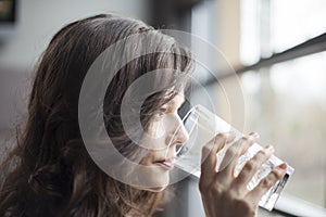 Young Woman Drinking a Pint Glass of Ice Water