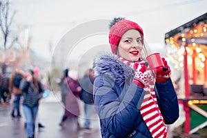 Young woman drinking punch on christmas market
