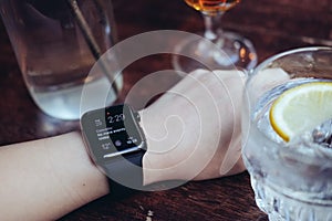 Young woman drinking with smart watch at bar