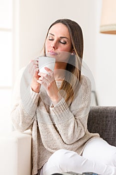 Young woman drinking something hot from her mug