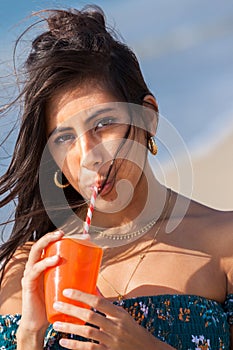 Young woman drinking through straw