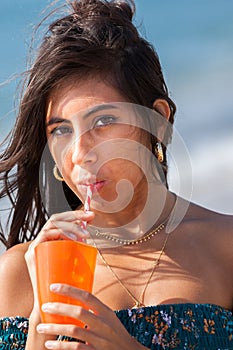 Young woman drinking through straw