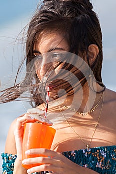 Young woman drinking through straw