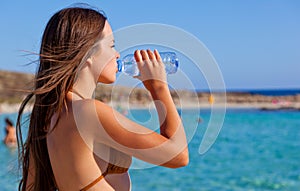 A young woman is drinking a water