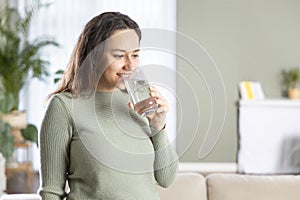 Young woman drinking water and smiling