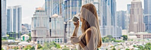 Young woman drinks coffee in the morning on the balcony overlooking the big city and skyscrapers BANNER long format