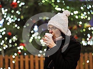 Young woman drinks a hot drink