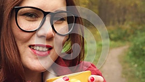 Young woman drinks hot tea from a mug to keep warm