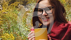 Young woman drinks hot tea from a mug to keep warm