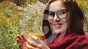 Young woman drinks hot tea from a mug to keep warm