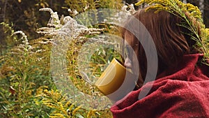 Young woman drinks hot tea from a mug to keep warm