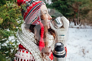 Young woman drinks tea in autumn forest