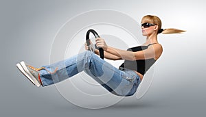 Young woman driver in sunglasses with a wheel