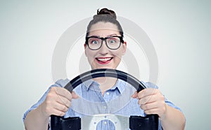 Young woman driver wearing glasses with steering wheel, auto concept