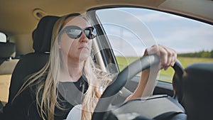 A young woman driving a car is driving on the highway.