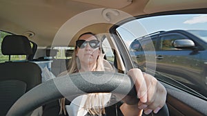 A young woman driving a car is driving on the highway.