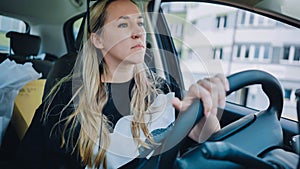 A young woman driving a car is driving on the highway.