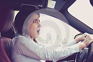 Young woman driving a car shocked about to have traffic accident