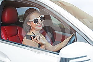 Mladá žena řízení auto a mluvení telefon na cesty 