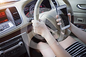 Young woman driving car using mobile phone while driving on road.