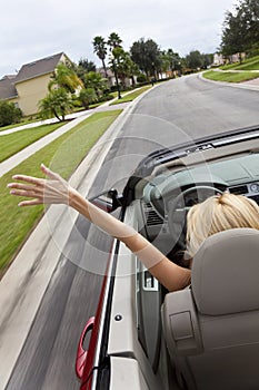 Young Woman Driving Convertible Car At Speed