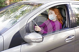 Young woman driving and wearing face mask