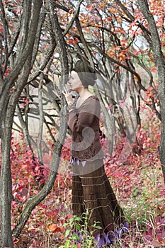 Young woman druid talking to a tree