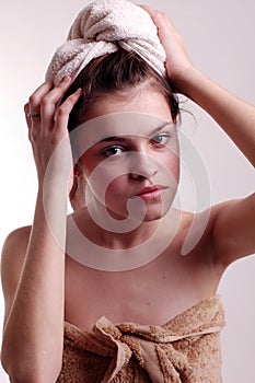 Young woman drying hair with towel