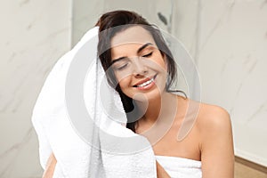 Young woman drying hair with towel