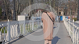 Young woman with e-scooter in coat at the city