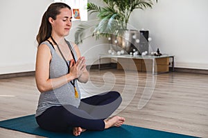 Young woman in early pregnancy meditating in a yoga studio