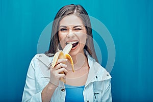 Young woman eat banana in order to feel happy.