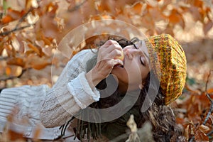 Young woman eating apple outdoor in autumn