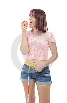 Young woman eating apple, on white