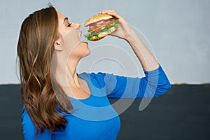 young woman eating big cheeseburger