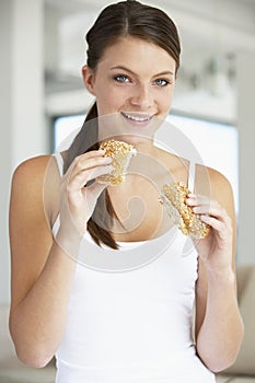 Young Woman Eating Brown Bread Roll