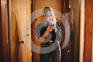 Young woman eating candy while using smart phone