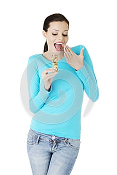 Young woman eating Cereal candy bar