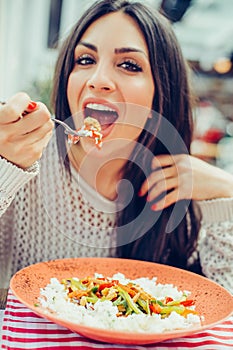Young woman eating chinese food in a restaurant, having her lunch break
