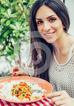 Young woman eating chinese food in a restaurant, having her lunch break