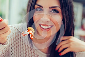 Young woman eating chinese food in a restaurant, having her lunch break