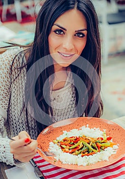 Young woman eating chinese food in a restaurant, having her lunch break