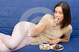 Young woman eating chocolate cookies.