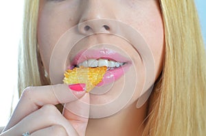 Young woman eating crisps
