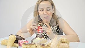 Young woman eating cupcakes with pleasure after a diet