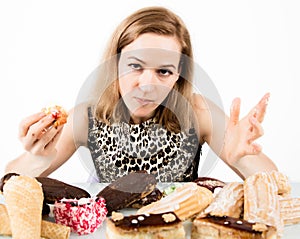 Young woman eating cupcakes with pleasure after a diet