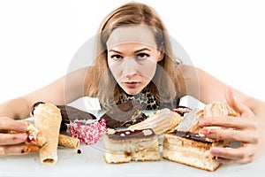 Young woman eating cupcakes with pleasure after a diet